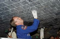Astronaut Andrew Thomas bekijkt het hitteschild van de spaceshuttle. Bron: Wikipedia