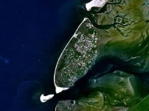 Texel, met aan de oostkant het wantij en de verbinding daarvan met het wantij van Vlieland. Ten zuiden van Texel is het Marsdiep, en rechtsonder de Afsluitdijk duidelijk zichtbaar. Bron: Wikipedia
